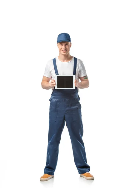 Smiling mover looking at camera and presenting digital tablet with blank screen isolated on white — Stock Photo