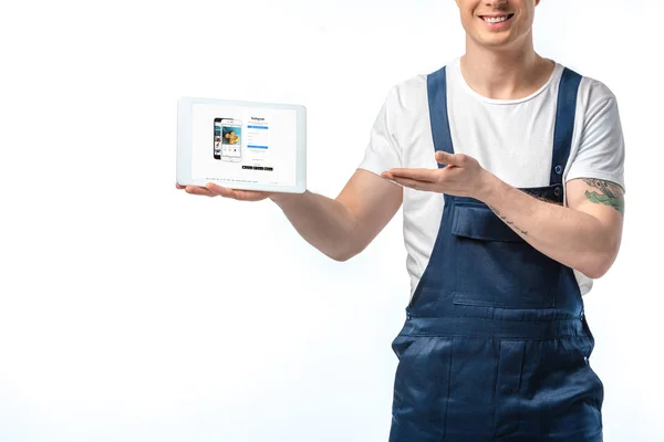 Ausgeschnittene Ansicht eines lächelnden Mover, der gestikuliert und ein digitales Tablet mit Instagram-App auf dem Bildschirm präsentiert, isoliert auf Weiß — Stockfoto