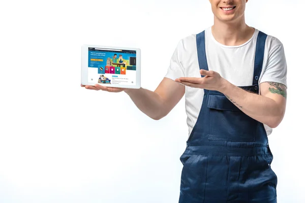 Vue recadrée du déménageur souriant gesticulant et présentant la tablette numérique avec l'application amazone à l'écran isolé sur blanc — Photo de stock