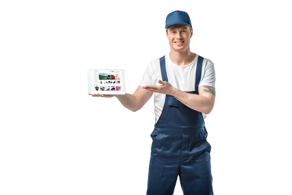 Schöner lächelnder Mover, der mit der Hand gestikuliert, während er ein digitales Tablet mit aliexpress App auf dem Bildschirm präsentiert, isoliert auf weiß — Stockfoto