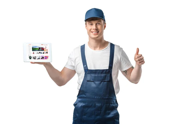 Handsome smiling mover showing thumb up and presenting digital tablet with aliexpress app on screen isolated on white — Stock Photo