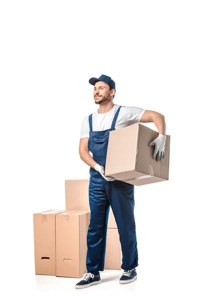 Beau déménageur en uniforme portant boîte en carton isolé sur blanc — Photo de stock