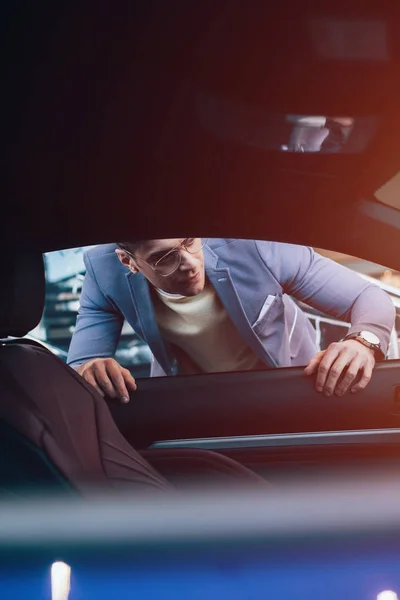 Selektiver Fokus eines gutaussehenden Mannes mit Brille, der in Automobil blickt — Stockfoto