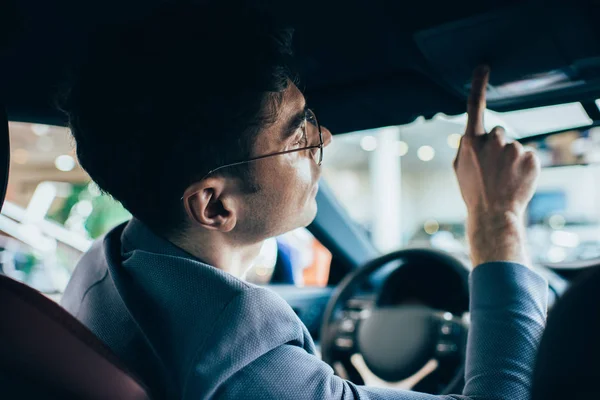 Foco seletivo do homem de sucesso em óculos gesticulando enquanto sentado no automóvel — Fotografia de Stock