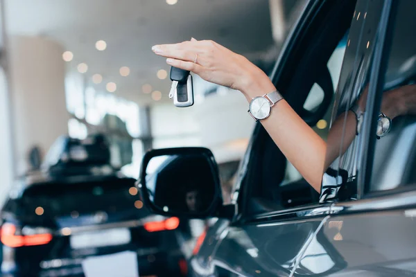 Vista ritagliata di donna in possesso di chiavi mentre seduto in automobile — Foto stock