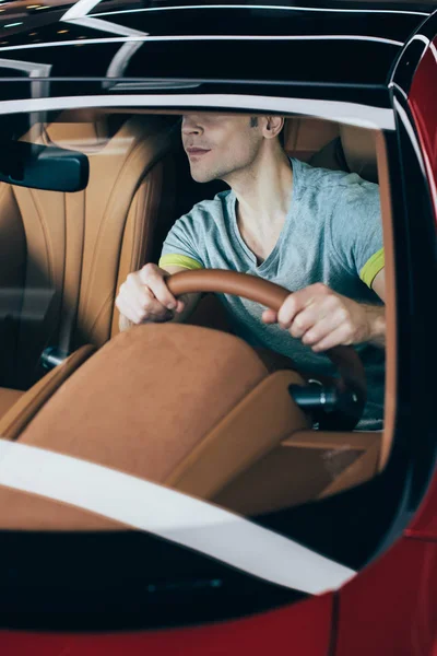 Vista parcial del hombre sentado en el coche y sosteniendo la silla de ruedas - foto de stock