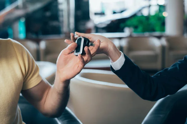 Selective focus of man taking keys from car dealer — Stock Photo