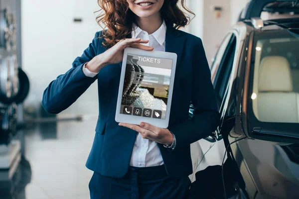 Cropped view of businesswoman holding digital tablet with tickets app on screen — Stock Photo