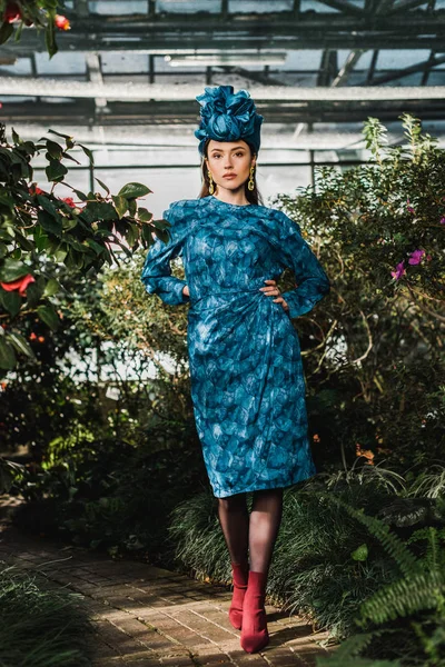 Ganzkörperansicht der attraktiven Frau in blauem Kleid und Turban in der Orangerie — Stockfoto