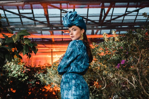 Linda jovem mulher em vestido azul em turbante em orangery — Fotografia de Stock