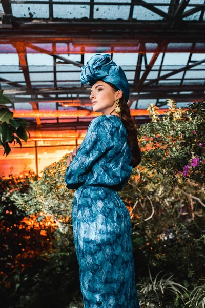 Hinreißende junge Frau in blauem Kleid mit Turban in Orangerie — Stockfoto