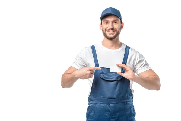 Sorrindo mover em uniforme olhando para a câmera e apontando com o dedo para o cartão de visita em branco isolado no branco — Fotografia de Stock