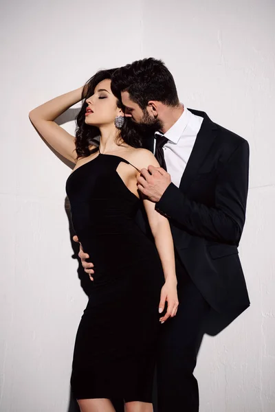 Брюнетка дівчина в чорній сукні стоїть з чоловіком на білому — Stock Photo