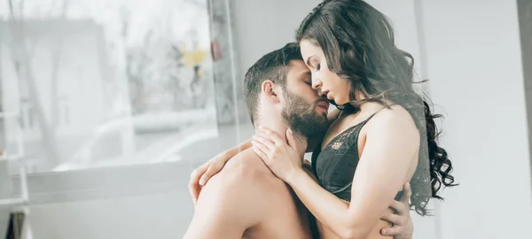 Tiro panorâmico de casal apaixonado beijando em casa — Fotografia de Stock