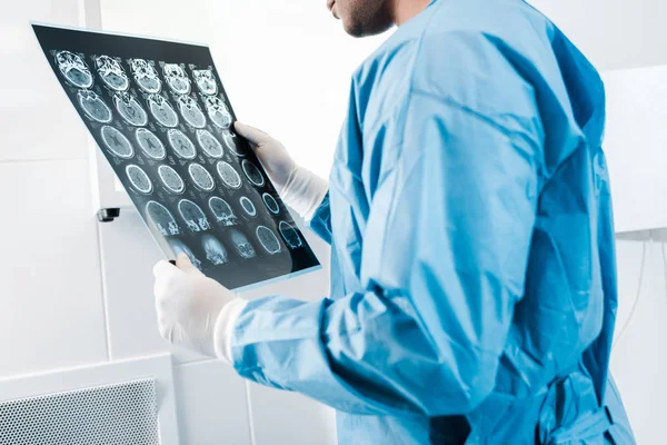 Partial view of doctor in uniform holding x-ray in clinic — Stock Photo