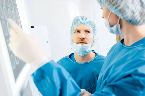 Enfoque selectivo de los médicos en uniformes hablando de rayos X en la clínica - foto de stock