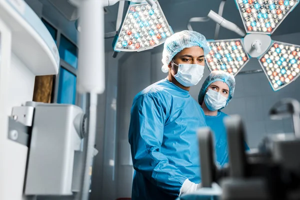 Selective focus of doctor and nurse in uniforms and medical masks — Stock Photo