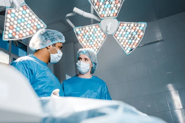 Selective focus of nurse doctor and nurse in medical masks and uniforms — Stock Photo