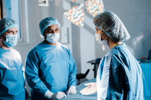 Selective focus of doctors and nurse in uniforms and medical masks talking — Stock Photo