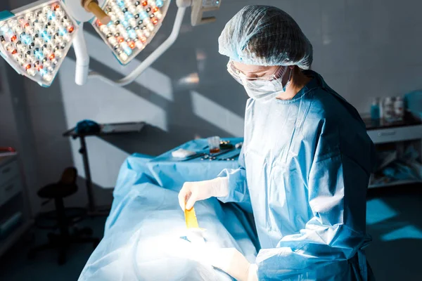 Nurse in uniform and latex gloves putting on strip in operating room — Stock Photo