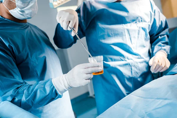 Visão cortada do cirurgião colocando tampão ao iodo na sala de cirurgia — Fotografia de Stock