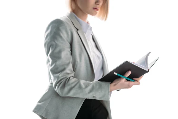 Vista parziale di donna d'affari in possesso di notebook e matita isolato su bianco — Foto stock