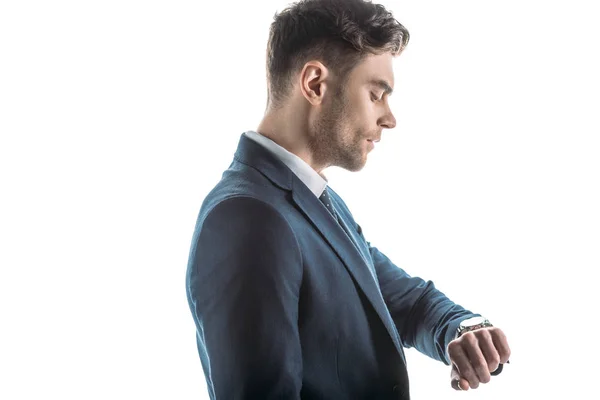 Guapo, hombre de negocios confiado mirando reloj aislado en blanco - foto de stock