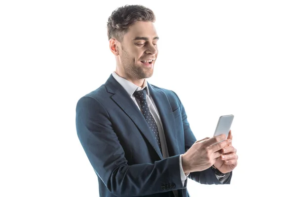 Hombre de negocios guapo y alegre usando un teléfono inteligente aislado en blanco - foto de stock