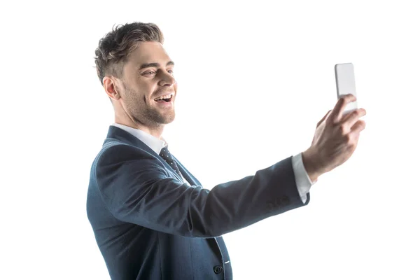 Guapo, alegre hombre de negocios tomando selfie con teléfono inteligente aislado en blanco - foto de stock