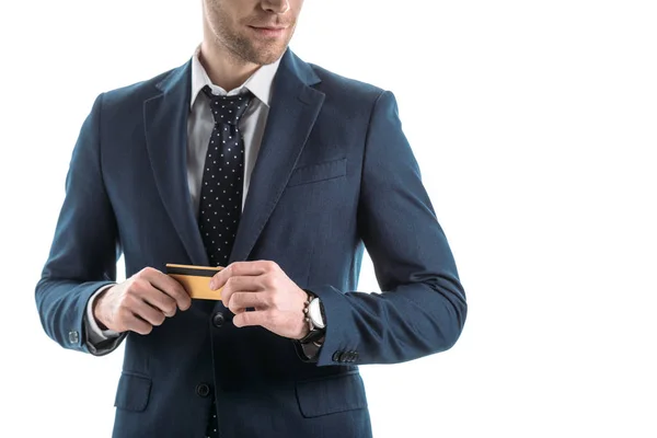 Vista parcial del hombre de negocios sonriente sosteniendo la tarjeta de crédito aislada en blanco - foto de stock