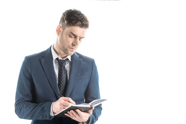 Gutaussehender, aufmerksamer Geschäftsmann schreibt in Notizbuch isoliert auf weiß — Stockfoto