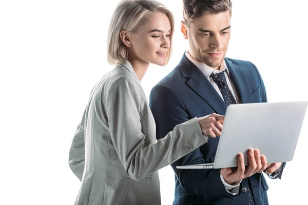 Femme d'affaires joyeuse pointant avec le doigt à l'écran d'ordinateur portable près de bel homme d'affaires isolé sur blanc — Photo de stock