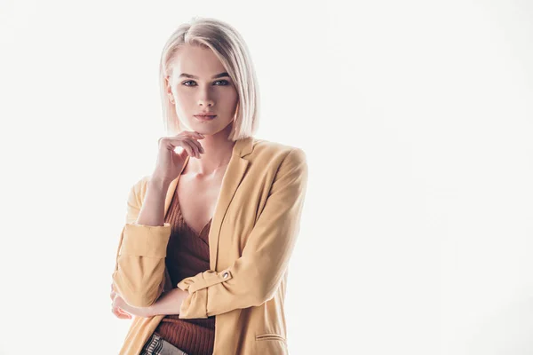 Beautiful, trendy woman with blonde hair looking at camera on grey — Stock Photo