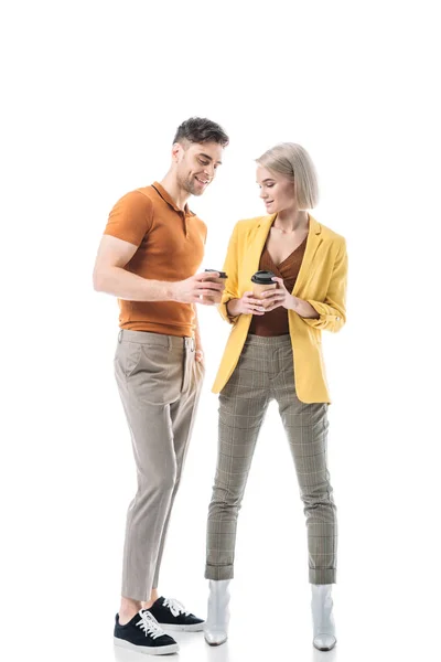 Jeune homme gai et femme tenant gobelets jetables isolés sur blanc — Photo de stock