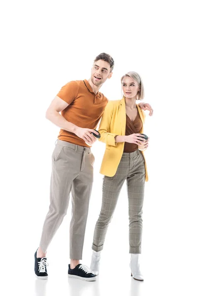 Smiling young man and woman holding coffee cups while standing together isolated on white — Stock Photo