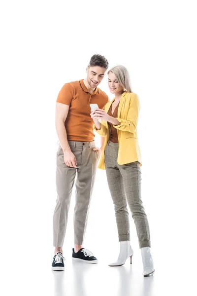 Усміхнений молодий чоловік і жінка дивиться на смартфон разом ізольовано на білому — стокове фото