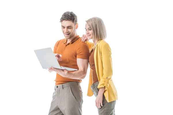 Cheerful handsome man and smiling woman using laptop together isolated on white — Stock Photo