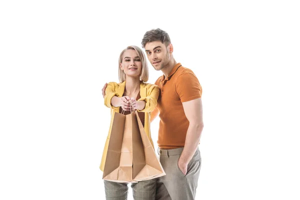 Happy pretty woman holding paper bags while standing near handsome man isolated on white — Stock Photo