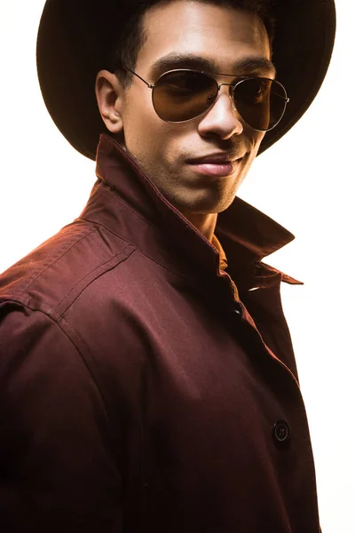 Fashionable mixed race man in sunglasses and hat posing isolated on white — Stock Photo