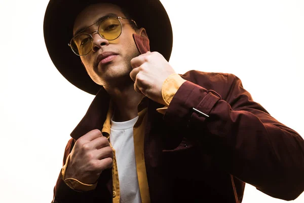 Stylish mixed race man in hat and sunglasses looking at camera and posing isolated on white — Stock Photo