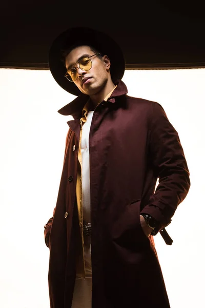 Stylish mixed race man in hat and sunglasses posing on black and white — Stock Photo