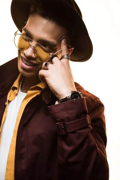 Élégant mixte homme en chapeau et lunettes de soleil souriant et gestuel isolé sur blanc — Stock Photo