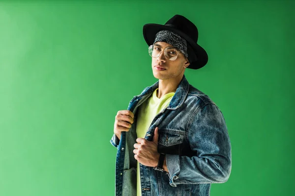 Stylish mixed race man posing and looking at camera on green screen with copy space — Stock Photo