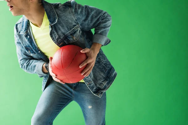 Cropped view of mixed race man in denim holding basketball on green screen with copy space — Stock Photo
