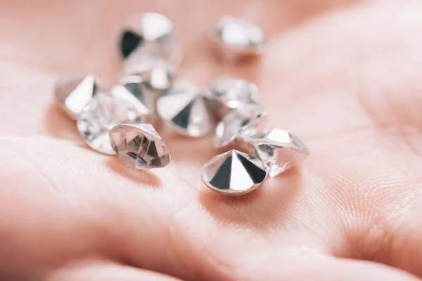 Close up of shiny small pure diamonds in hand — Stock Photo