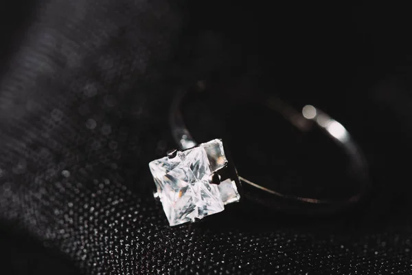 Bague de fiançailles avec diamant étincelant pur sur tissu noir — Photo de stock