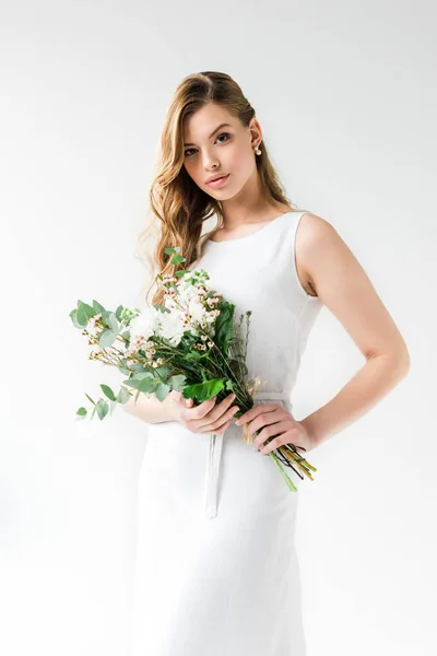 Attrayant jeune femme en robe tenant des fleurs sur blanc — Photo de stock