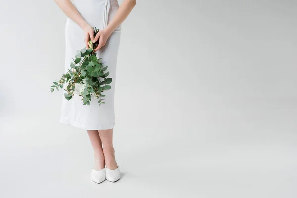 Vue recadrée de la femme debout avec des fleurs sur gris — Photo de stock