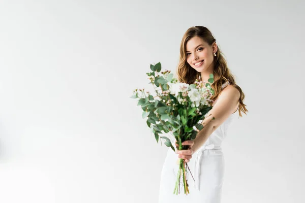 Foco seletivo de menina alegre que mantém o buquê de flores no branco — Fotografia de Stock