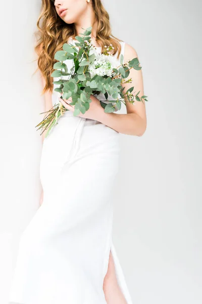 Vista ritagliata di giovane donna che tiene mazzo di fiori su bianco — Foto stock